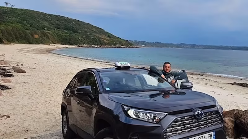 tarifs taxi Pleumeur-Bodou, chauffeur de taxi, au volant de son Toyota RAV4 sur une plage de la Côte de Granit Rose, près de Pleumeur-Bodou